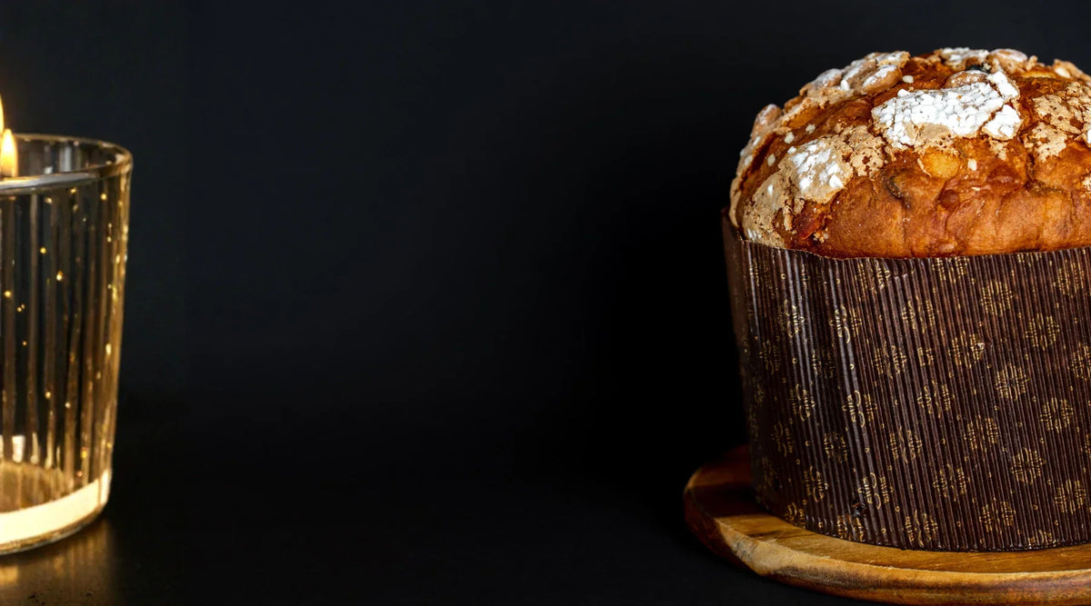 Panettone artisanal italien sur fond noir, brioche traditionnelle de Noël avec croûte dorée et sucre perlé