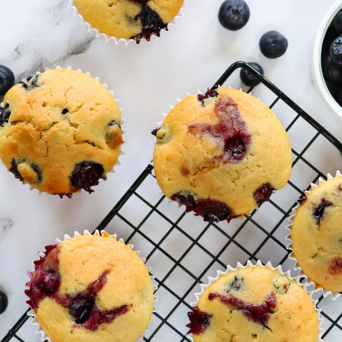 Muffins véganes aux myrtilles fraîchement cuits, présentés sur une assiette.