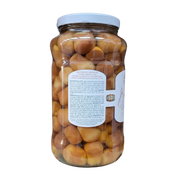 Baba au rhum en bocal avec étiquette latérale détaillant les ingrédients et les instructions, vue sur la transparence des babas imbibés de sirop.