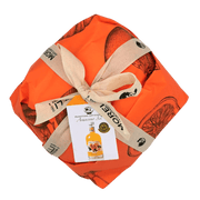 Panettone artisanal Arancino 32° avec liqueur à l’orange Morelli, emballé dans un papier orange avec ruban. Panettone à la liqueur.