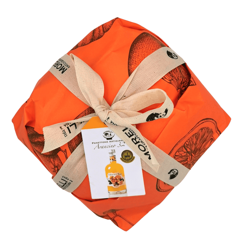 Panettone artisanal Arancino 32° avec liqueur à l’orange Morelli, emballé dans un papier orange avec ruban. Panettone à la liqueur.